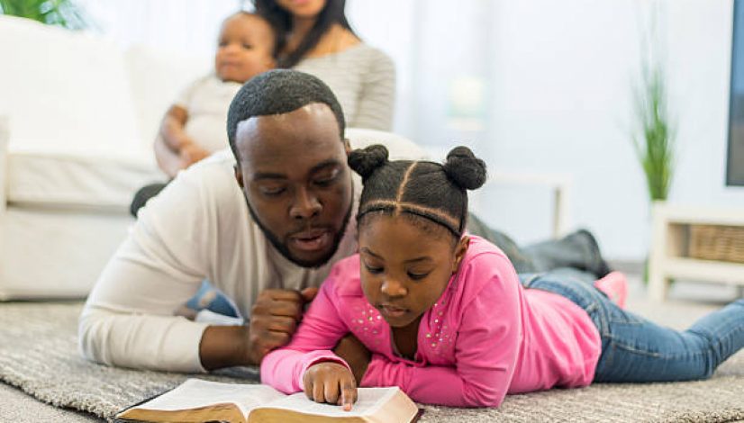 Father and daughter reading the Bible together.